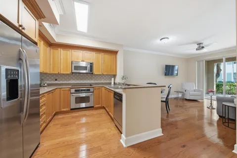 a large white kitchen with stainless steel appliances granite countertop a stove and a sink