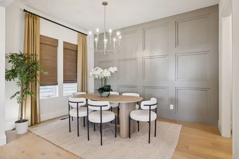a kitchen with kitchen island granite countertop a table chairs sink and cabinets