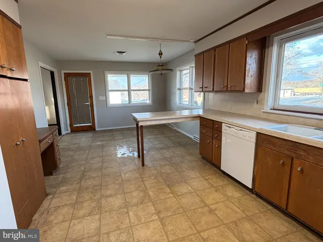 a view of a kitchen with cabinets and a window