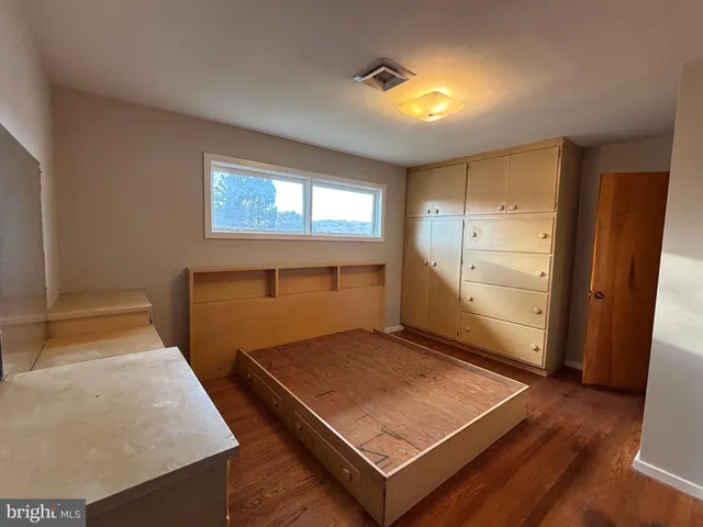 a view of a hallway with wooden floor and closet