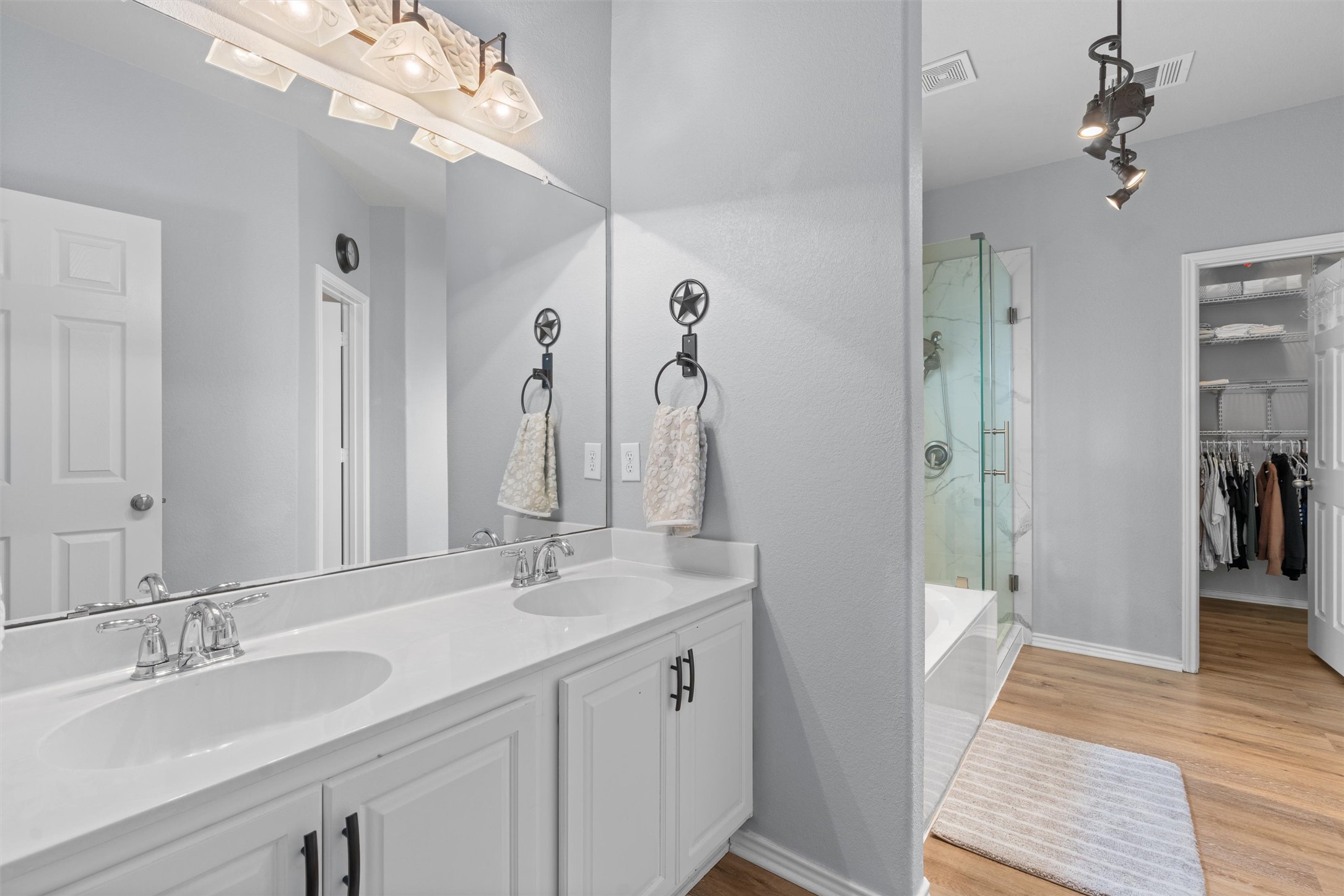 338 Altamont Street Hutto, TX 78634 - Photo 15 of 40 Full bath featuring a spacious closet, a stall shower, double vanity, light wood finished floors, and a tub to relax in