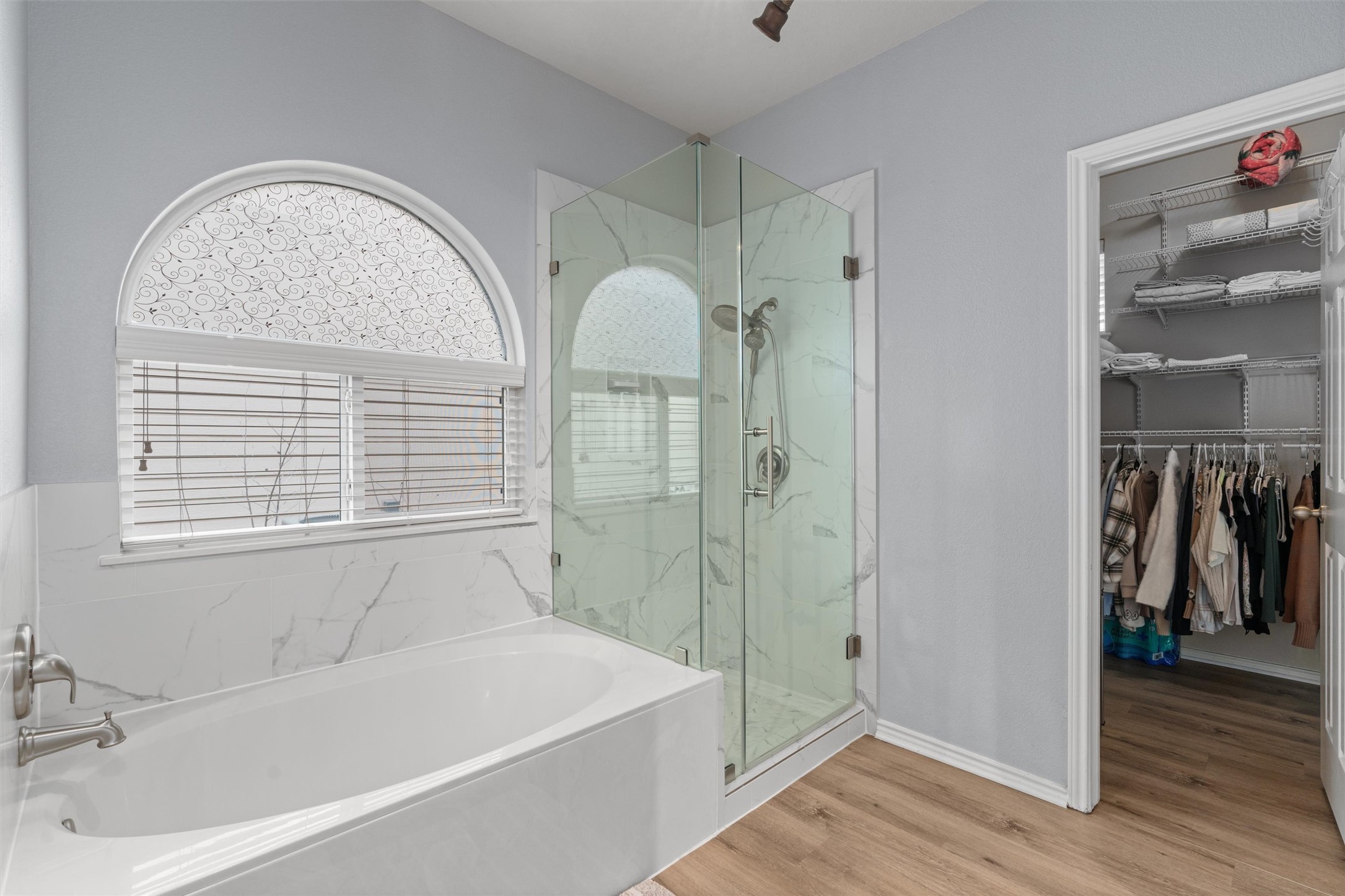 338 Altamont Street Hutto, TX 78634 - Photo 16 of 40 Bathroom featuring a marble finish shower, a bath, a spacious closet, and light wood finished floors