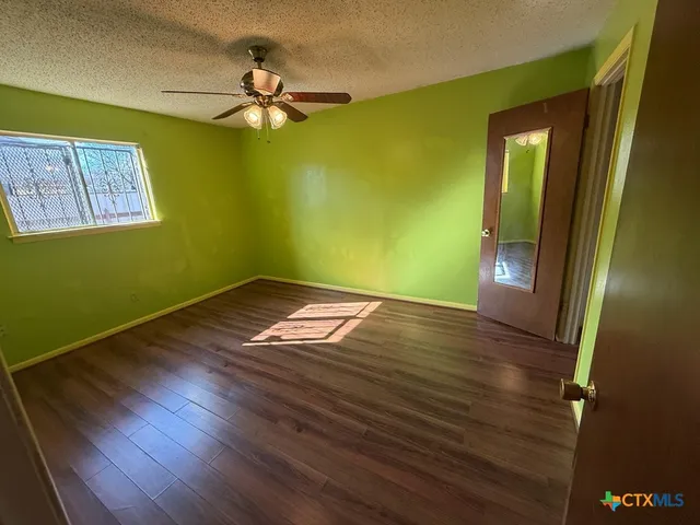 a view of empty room with wooden floor