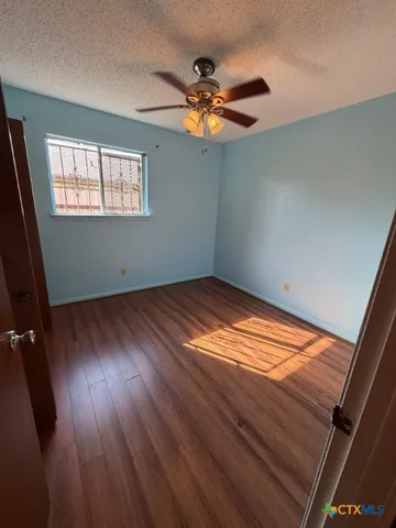 a view of wooden floor in an empty room with a window
