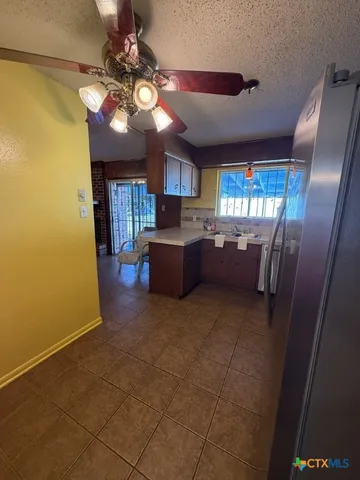 a view of a livingroom with kitchen and window