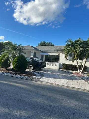 a front view of a house with a garden and yard