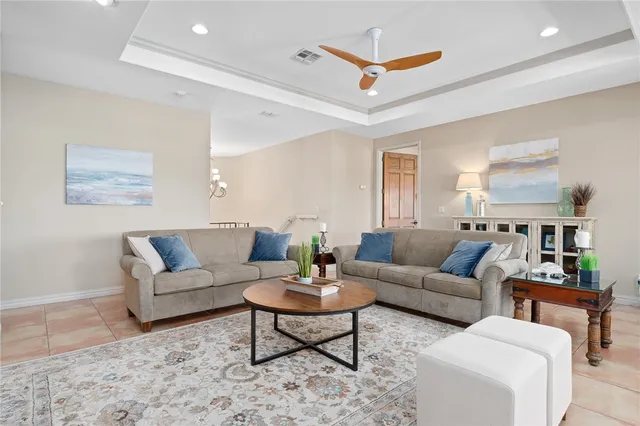 a living room with furniture a rug and a ceiling fan