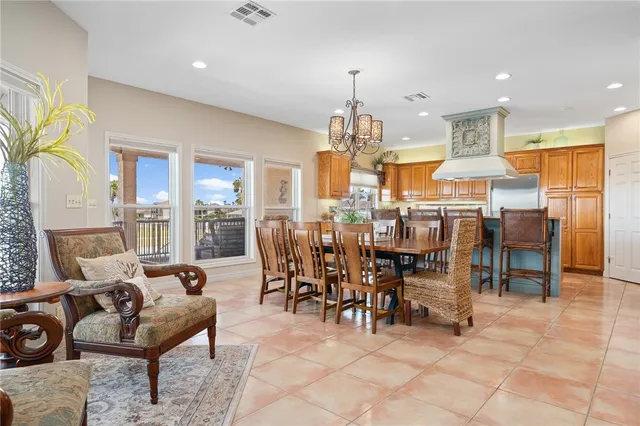 a view of a dining room with furniture a chandelier and a rug
