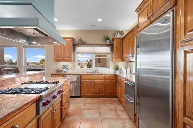 a kitchen with stainless steel appliances granite countertop a sink and a refrigerator