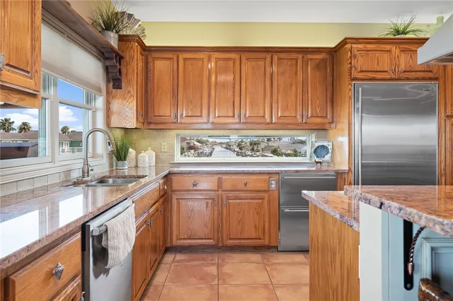 a kitchen with stainless steel appliances granite countertop a refrigerator and a stove