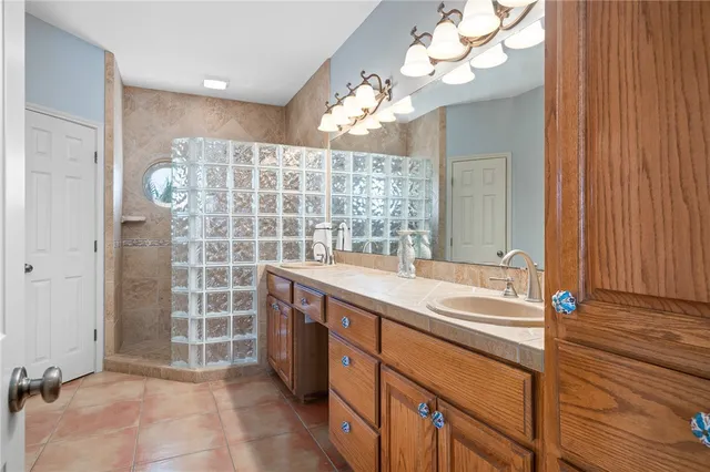 a spacious bathroom with a sink a large mirror and a shower
