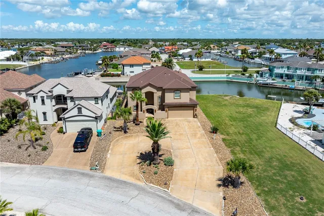an aerial view of a house with a garden and lake view
