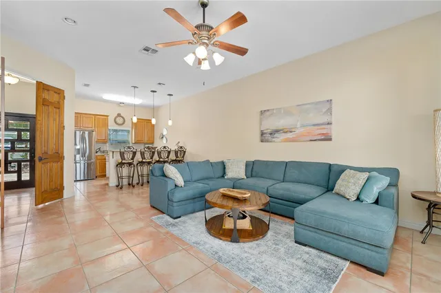 a living room with furniture and a view of kitchen