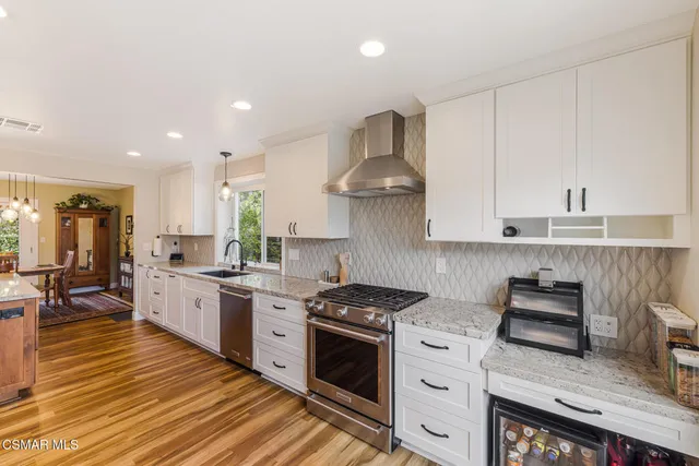 a kitchen with stainless steel appliances granite countertop a stove a sink and a refrigerator