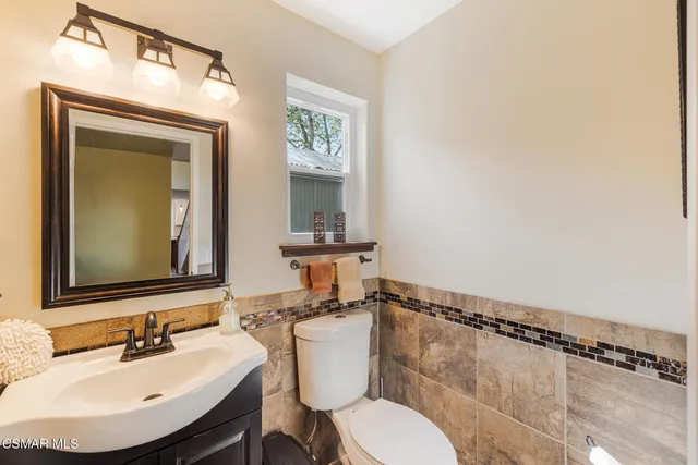 a bedroom with a bed and a dresser next to a window