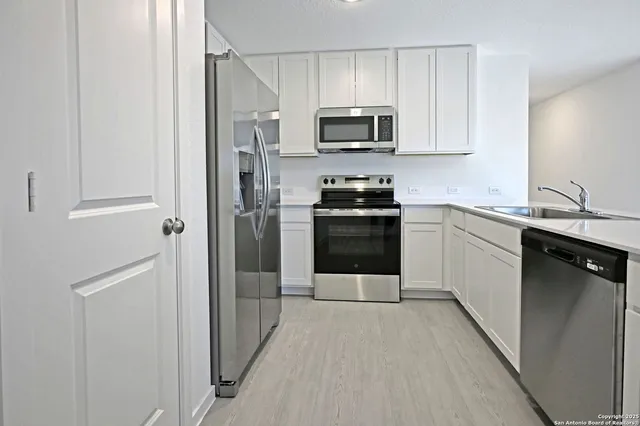 a kitchen with a sink appliances and cabinets