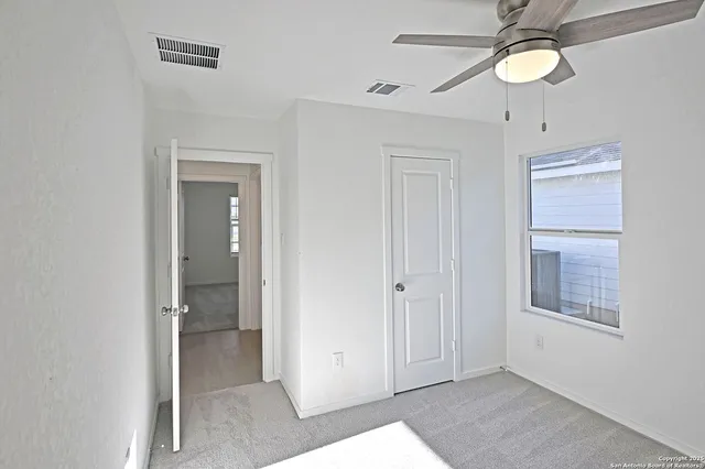 a view of a hallway with wooden floor and cabinet