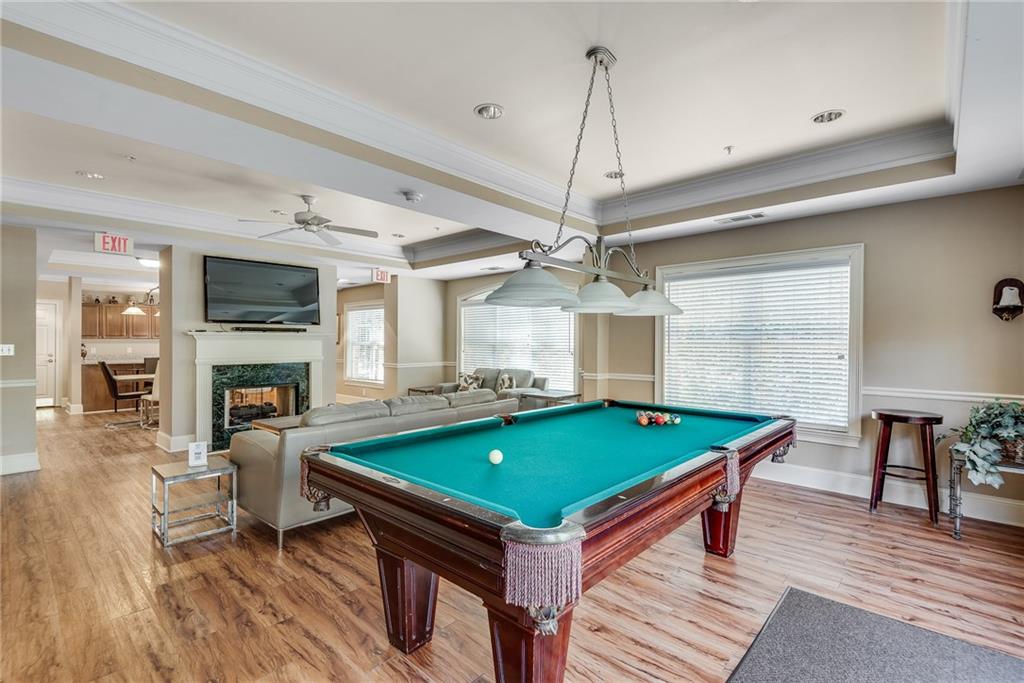 3275 Lenox Road Northeast, Unit 108 Atlanta, GA 30324 - Photo 18 of 22 a room with pool table flat screen tv wooden floor and chandelier