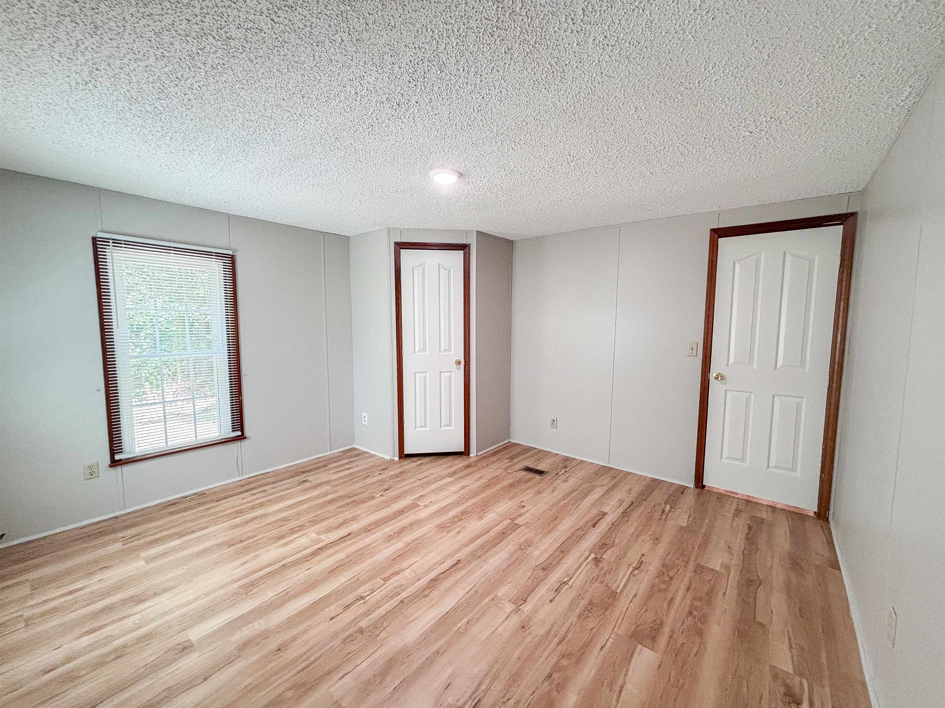 471 Milton Road Millington, TN 38053 - Photo 20 of 30 Wood-finish flooring, paneled walls, recessed ceiling lighting, and a white interior door with dark wood trim