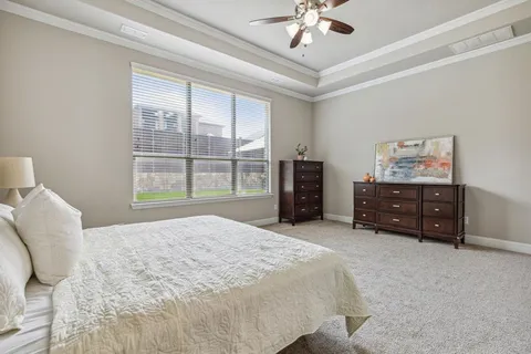 a spacious bedroom with a bed dresser and a window