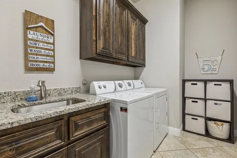 a utility room with sink dryer and washer