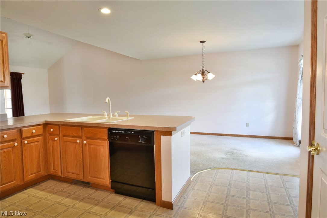2033 East River Road, Unit 11 Newton Falls, OH 44444 - Photo 8 of 35 Kitchen with vaulted ceiling, light countertops, light carpet, and black dishwasher