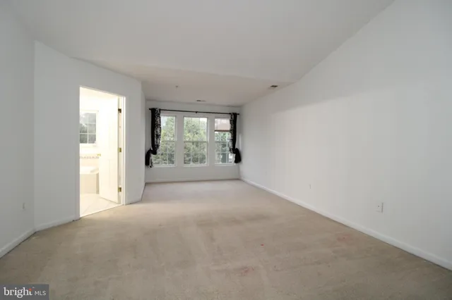 a view of a big room with windows and chandelier fan