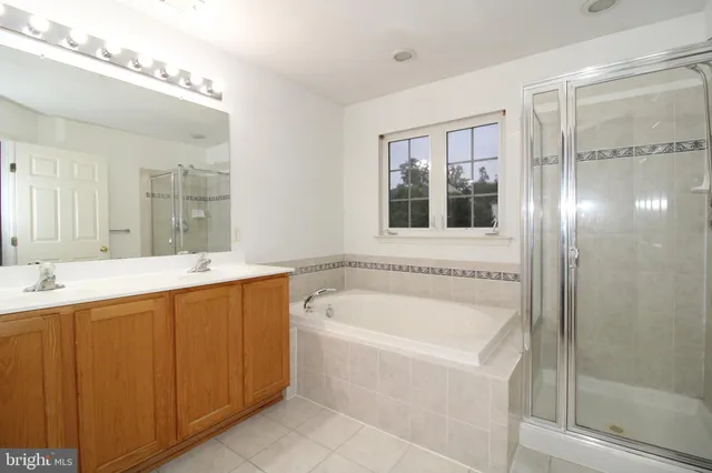 a bathroom with a tub a sink and mirror