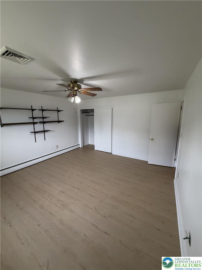 5391 Chapmans Road, Unit 2 Orefield, PA 18069 - Photo 19 of 22 A well-lit bedroom features durable laminate flooring and a functional ceiling fan.
