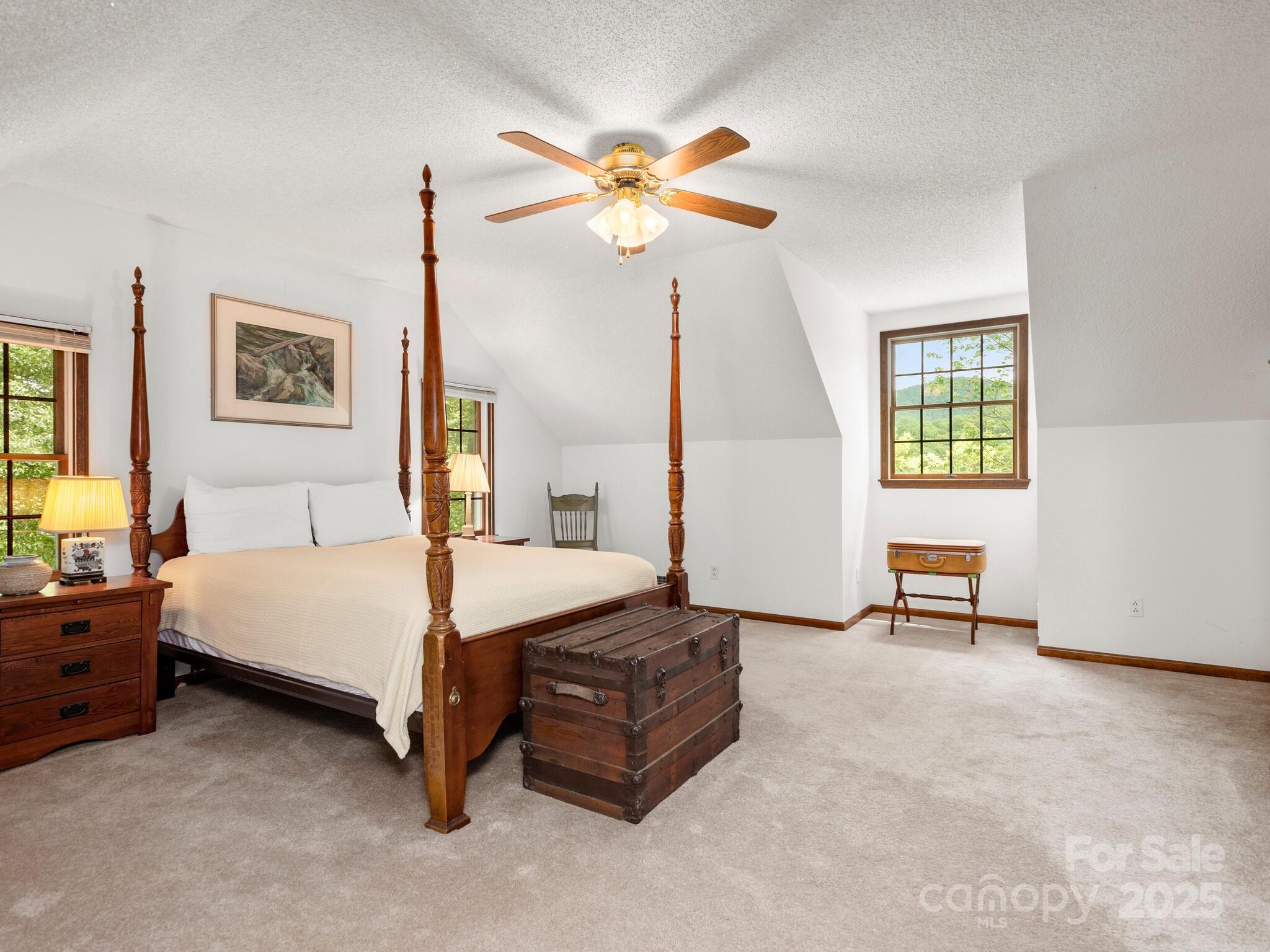 116 Sams Branch Road Candler, NC 28715 - Photo 25 of 47 a spacious bedroom with a bed and a chandelier