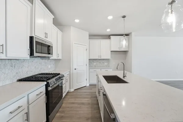 a kitchen with granite countertop white cabinets and white appliances