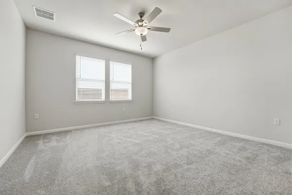 an empty room with a window and a ceiling fan