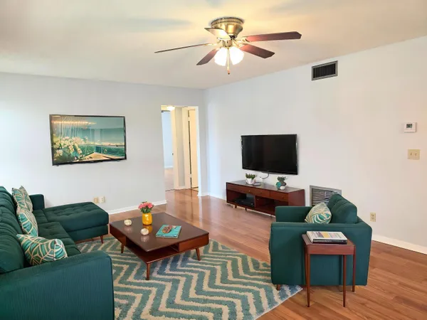 a living room with furniture and a wooden floor