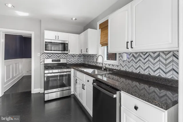 a kitchen with stainless steel appliances granite countertop a sink and a stove