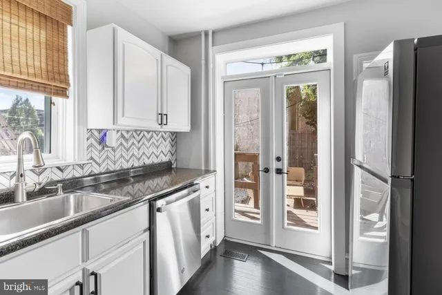 a kitchen with stainless steel appliances granite countertop a refrigerator and a sink