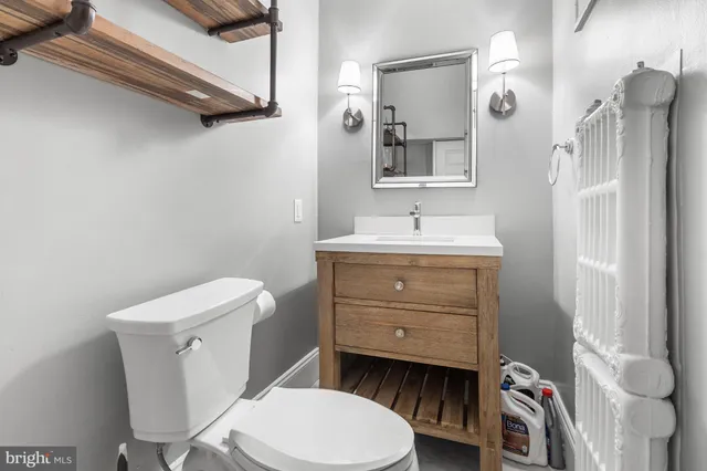 a bathroom with a toilet a sink and mirror