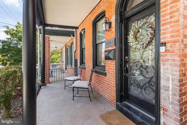 a porch with a bench next to a yard