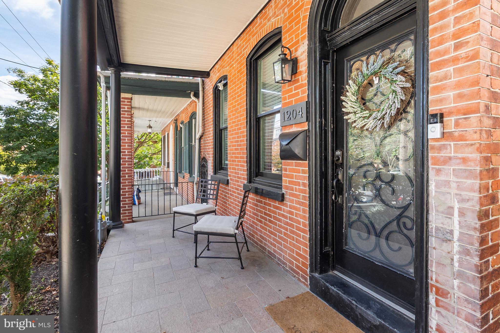 1204 West 8th Street Wilmington, DE 19806 - Photo 2 of 35 a porch with a bench next to a yard