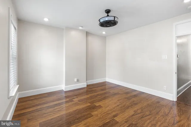 a view of an empty room with wooden floor