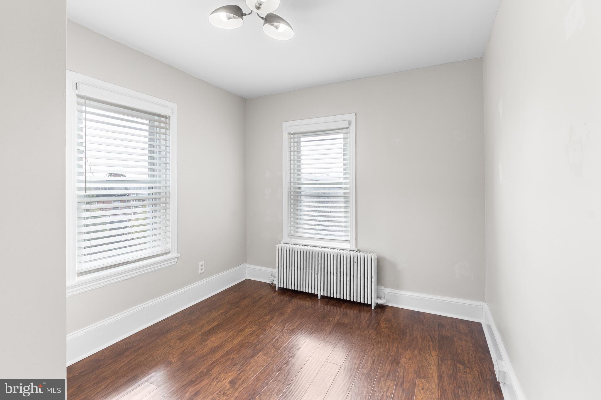 1204 West 8th Street Wilmington, DE 19806 - Photo 26 of 35 an empty room with wooden floor and windows
