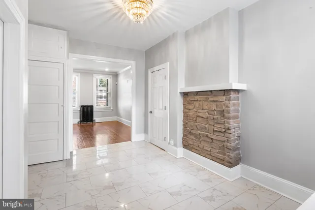 an empty room with kitchen view and natural light