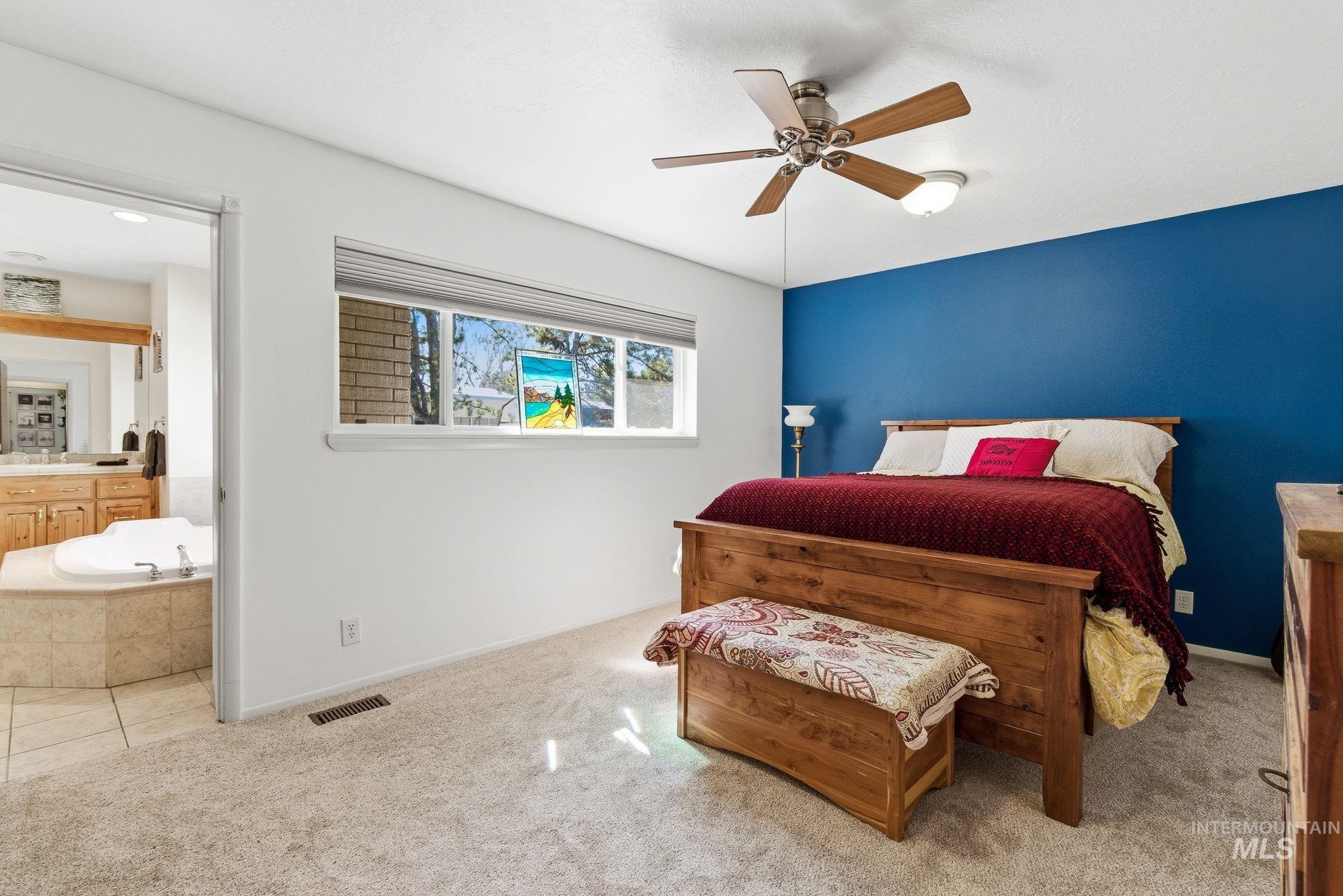 12055 West McMillan Road Boise, ID 83713 - Photo 14 of 42 Bedroom with ceiling fan, carpet, and ensuite bath