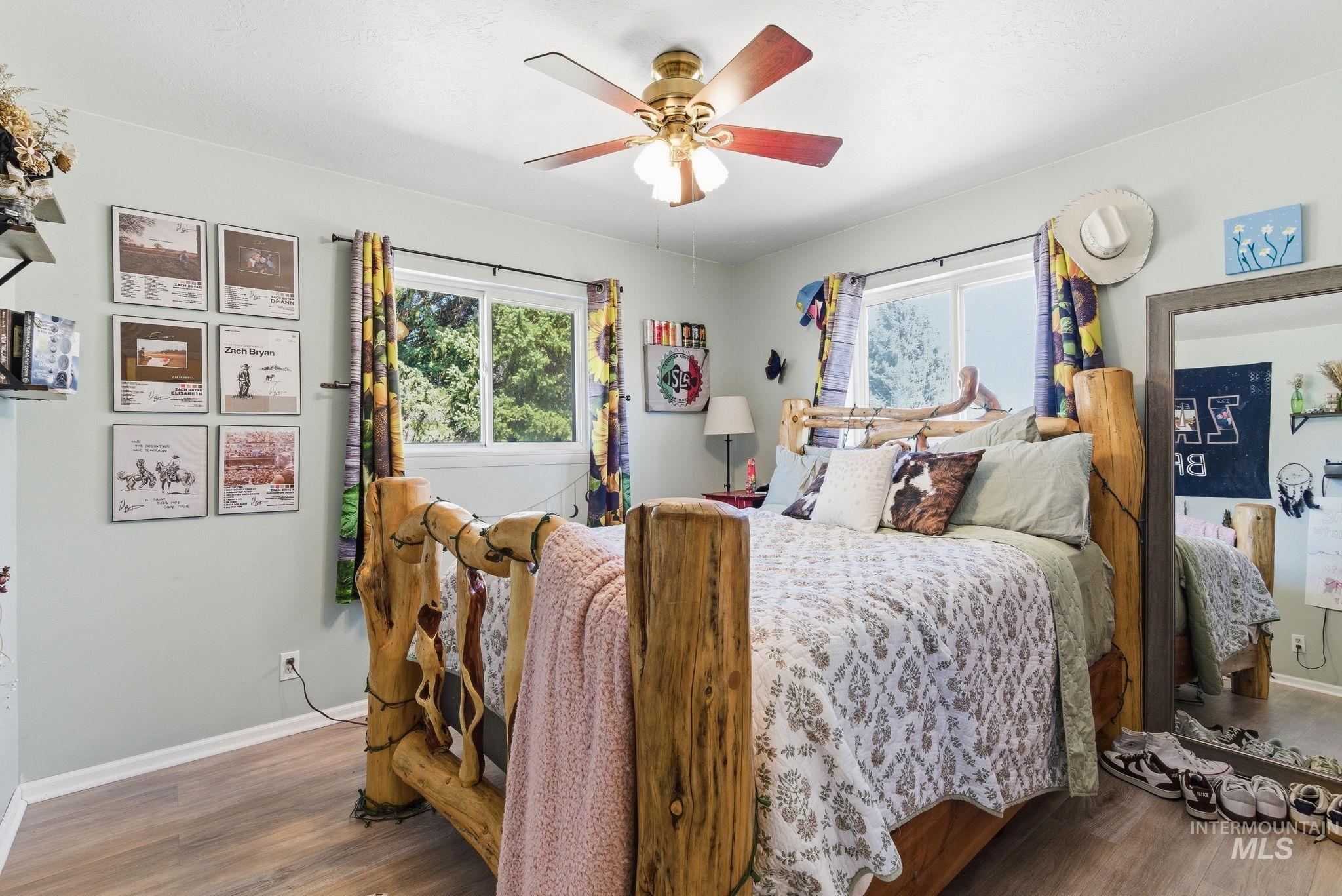 12055 West McMillan Road Boise, ID 83713 - Photo 18 of 42 Bedroom with multiple windows, wood finished floors, and a ceiling fan