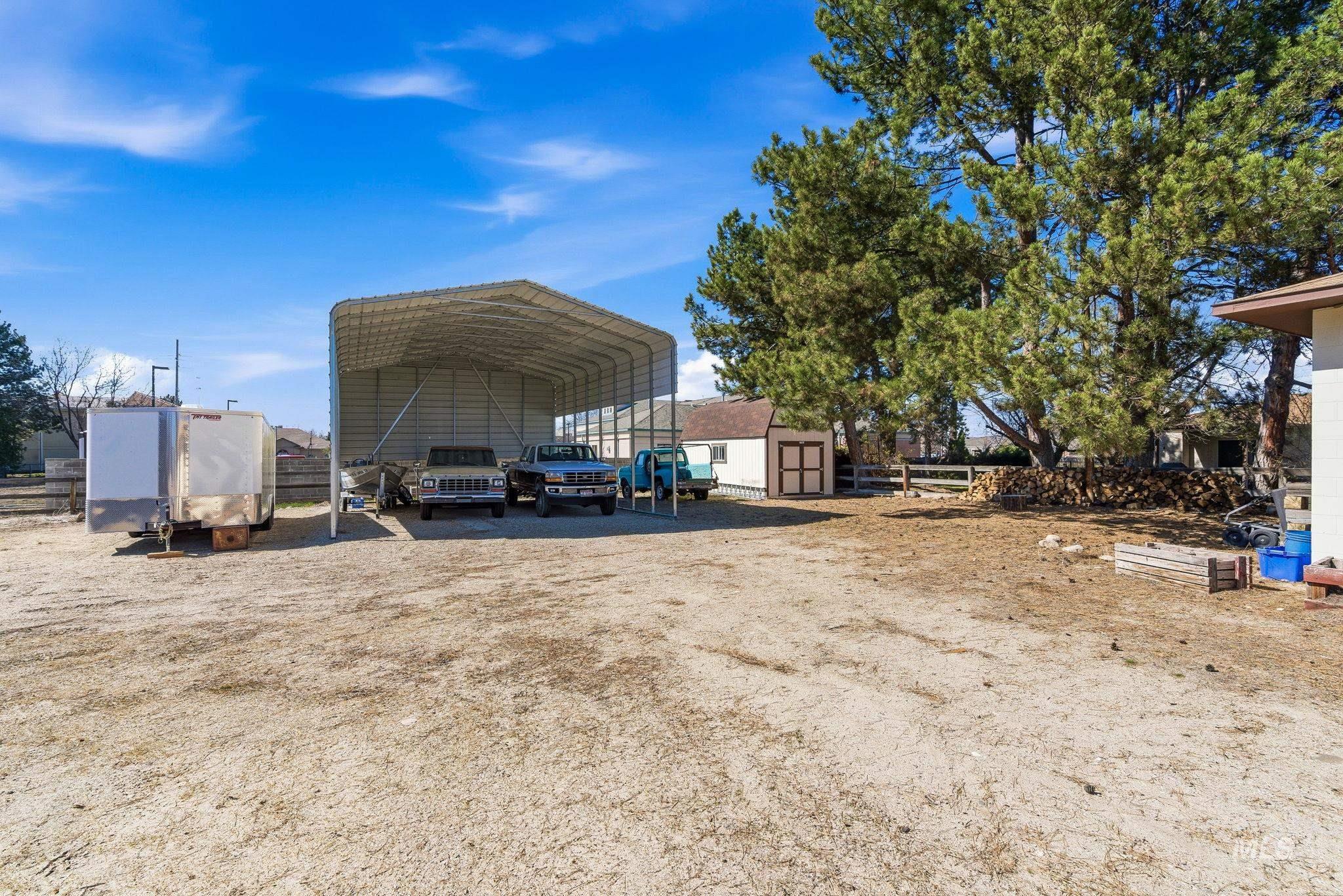 12055 West McMillan Road Boise, ID 83713 - Photo 32 of 42 View of parking featuring a shed, a carport, and driveway