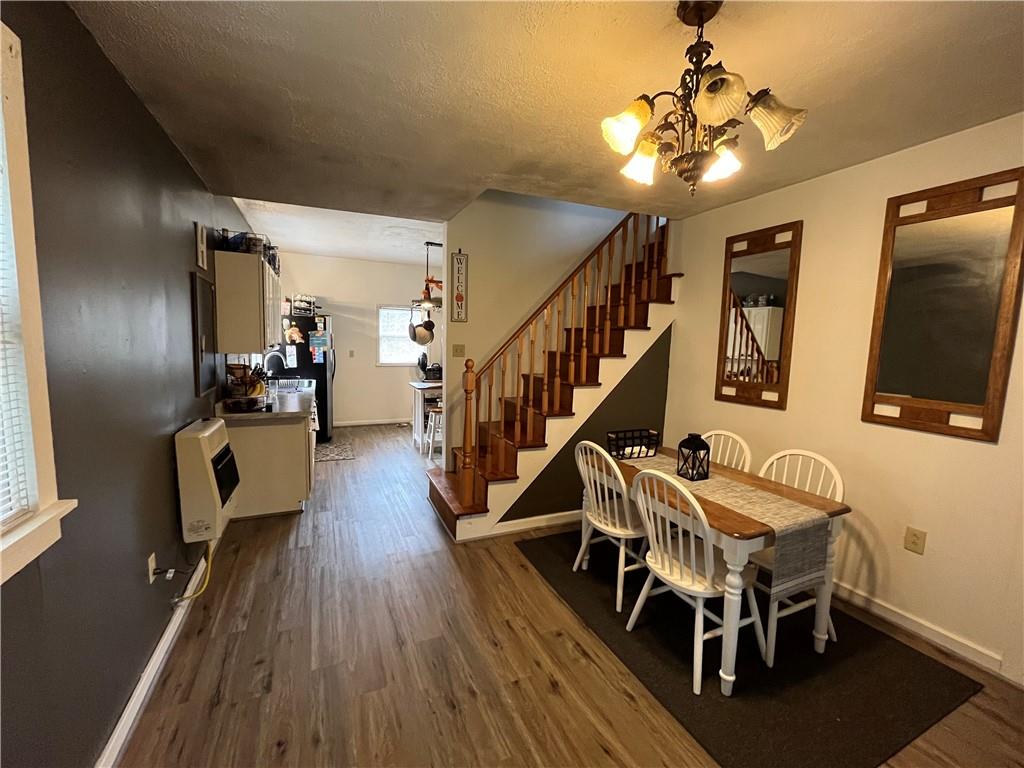 197 Oak Road Holbrook, PA 15341 - Photo 5 of 17 a dining room with wooden floor a chandelier a wooden table and chairs