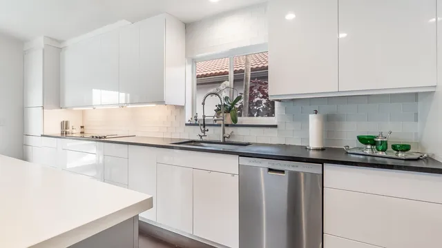 a kitchen with stainless steel appliances granite countertop a sink a stove and cabinets