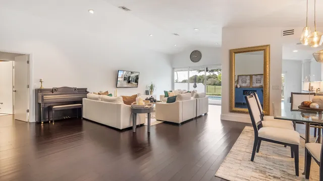 a living room with furniture wooden floor and a large window
