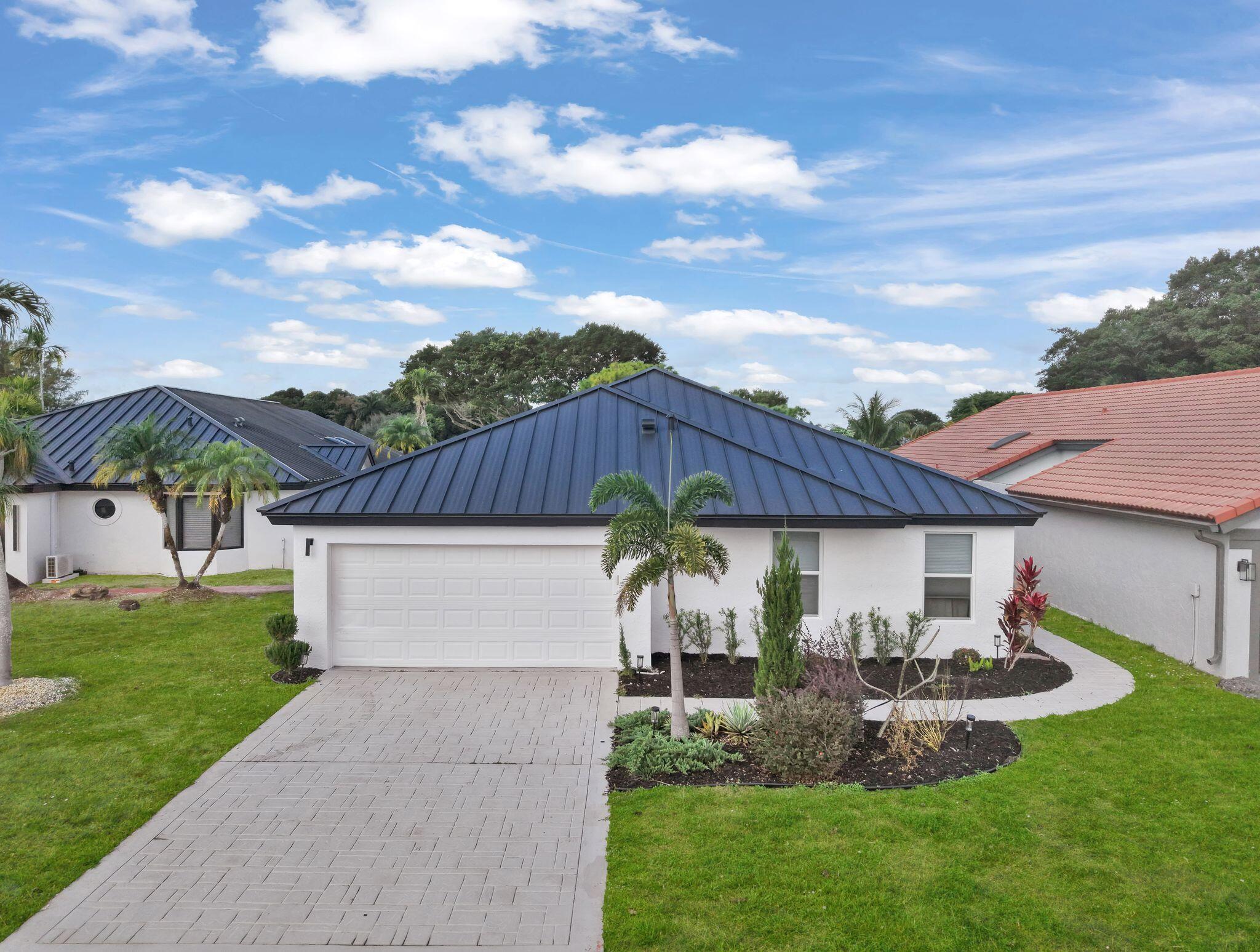 10208 Sunset Bend Drive Boca Raton, FL 33428 - Photo 26 of 40 a front view of a house with a garden