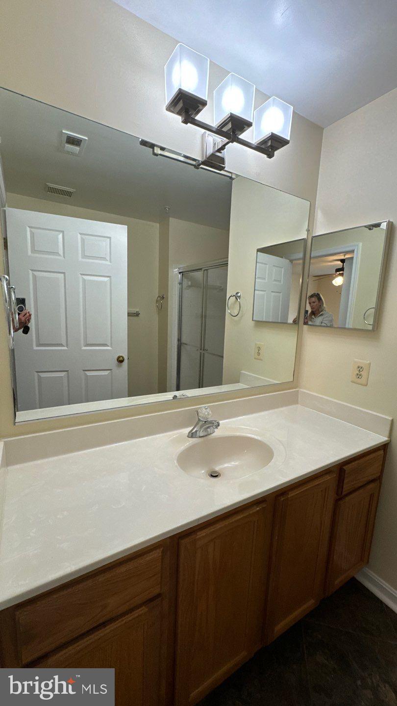 9150 Gracious End Court, Unit 103 Columbia, MD 21046 - Photo 15 of 18 a bathroom with a sink vanity and a mirror