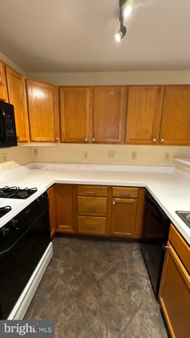 a kitchen with wooden cabinets and a stove top oven